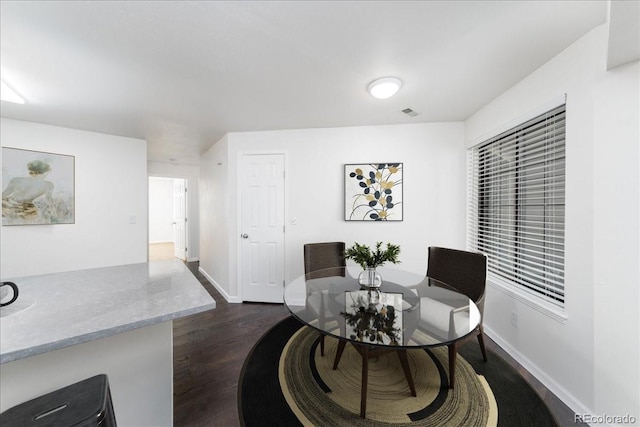 living area featuring dark wood finished floors, visible vents, and baseboards