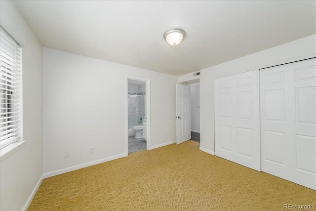 unfurnished bedroom with a closet, visible vents, multiple windows, and baseboards