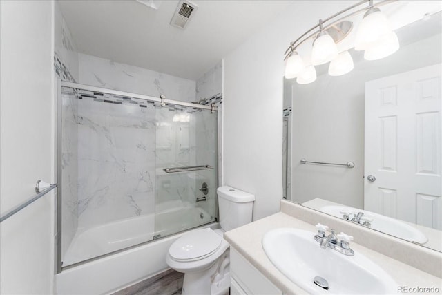 full bathroom with visible vents, toilet, wood finished floors, combined bath / shower with glass door, and vanity