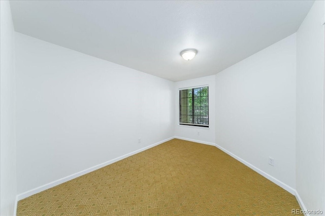 empty room featuring carpet flooring and baseboards