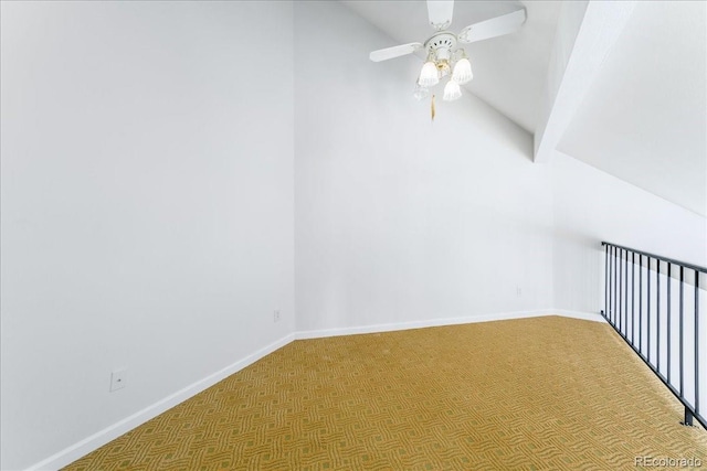 interior space featuring vaulted ceiling, carpet flooring, a ceiling fan, and baseboards