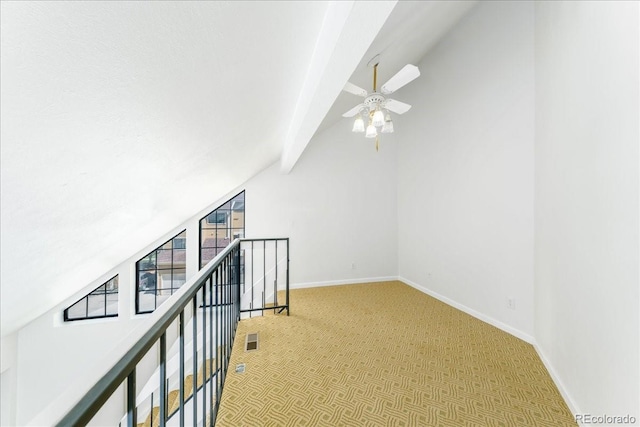 additional living space with a ceiling fan, carpet, baseboards, visible vents, and lofted ceiling with beams