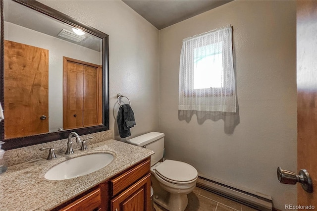 bathroom with visible vents, vanity, toilet, tile patterned floors, and a baseboard heating unit