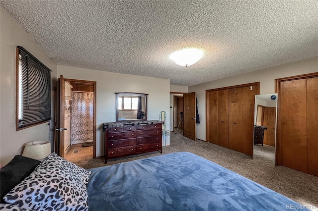 bedroom featuring two closets, a textured ceiling, and carpet flooring