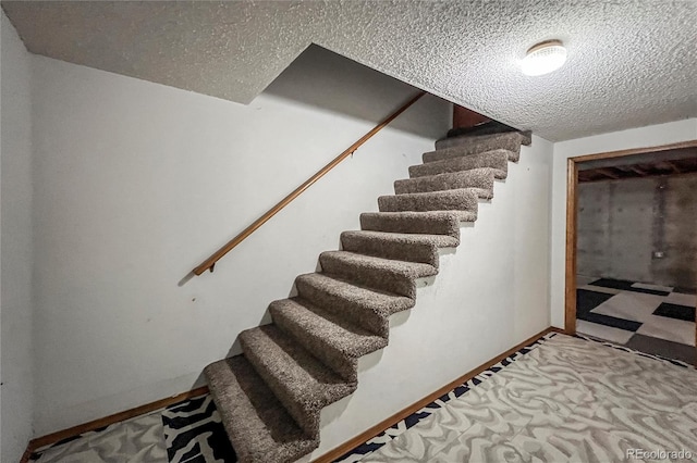 staircase featuring a textured ceiling