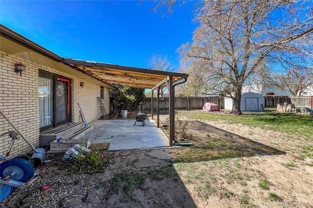 view of yard featuring a storage shed, a patio, an outdoor structure, and a fenced backyard