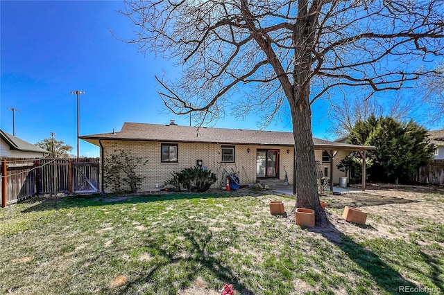rear view of house featuring a fenced backyard, a yard, a patio area, and brick siding