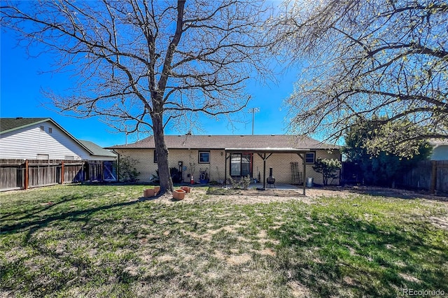 rear view of property featuring a fenced backyard, a yard, and a patio area