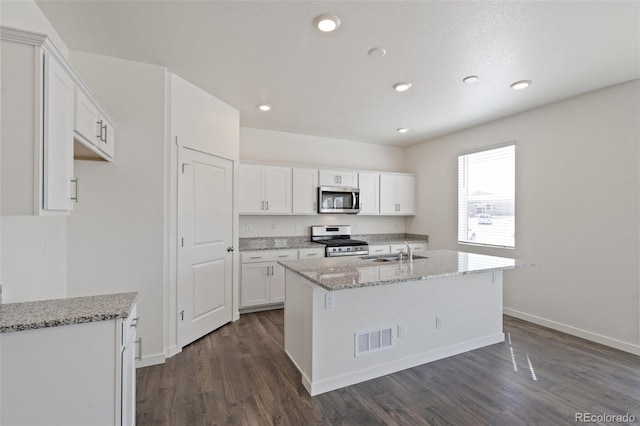 18126 Coppermallow Trl, Parker, CO 80134 - kitchen with stainless steel appliances, dark wood-type flooring, white cabinetry, light stone counters, and recessed lighting