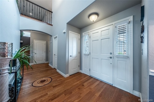 9758 Red Oakes Dr, Highlands Ranch, CO 80126 - foyer featuring wood finished floors, arched walkways, and plenty of natural light