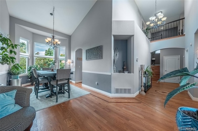 9758 Red Oakes Dr, Highlands Ranch, CO 80126 - dining area with a chandelier, arched walkways, high vaulted ceiling, and wood finished floors