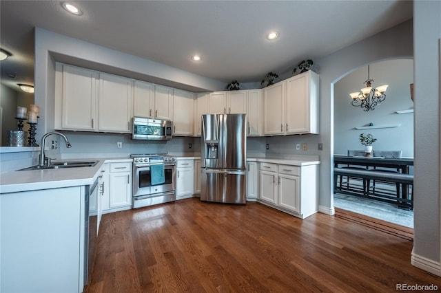9758 Red Oakes Dr, Highlands Ranch, CO 80126 - kitchen with stainless steel appliances, a chandelier, light countertops, dark wood-style floors, and white cabinets