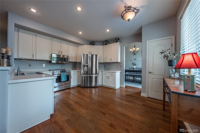 9758 Red Oakes Dr, Highlands Ranch, CO 80126 - kitchen featuring appliances with stainless steel finishes, light countertops, dark wood-style floors, a chandelier, and white cabinets