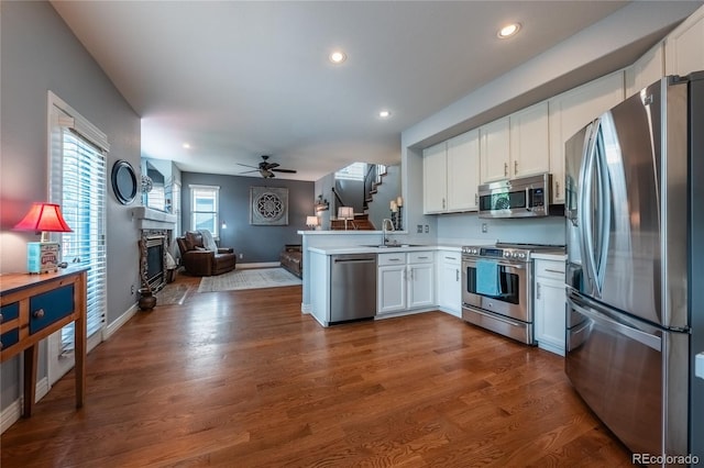 9758 Red Oakes Dr, Highlands Ranch, CO 80126 - kitchen with stainless steel appliances, open floor plan, white cabinets, and recessed lighting