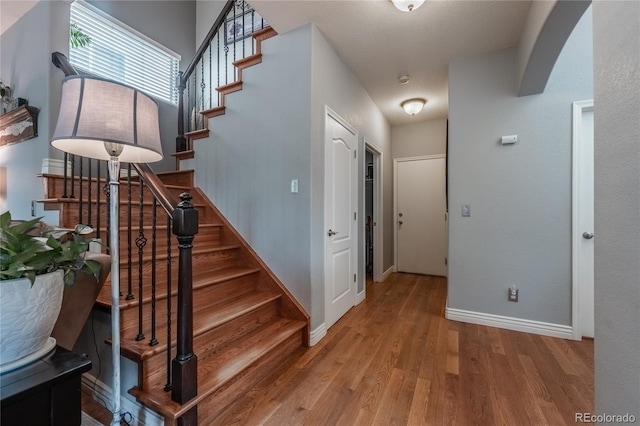 9758 Red Oakes Dr, Highlands Ranch, CO 80126 - stairs featuring wood finished floors and arched walkways