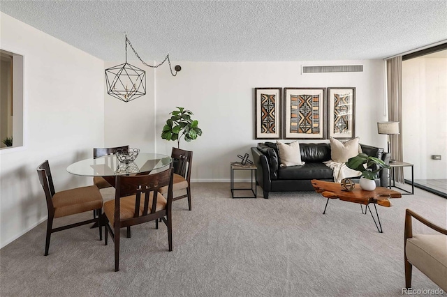 carpeted dining area featuring visible vents and a textured ceiling