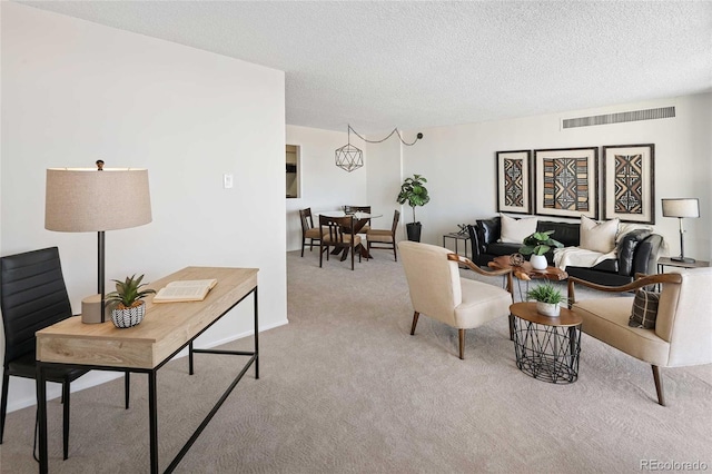 living room with visible vents, carpet floors, and a textured ceiling