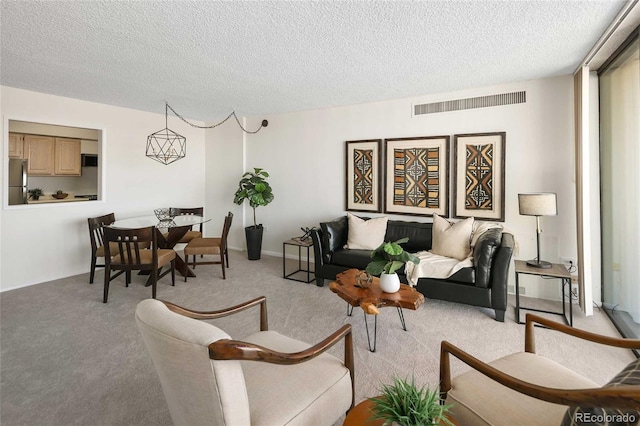 living area with light carpet, visible vents, and a textured ceiling