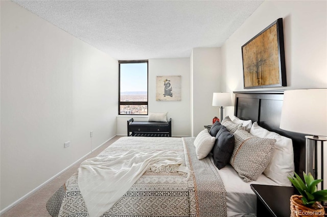 carpeted bedroom featuring baseboards and a textured ceiling