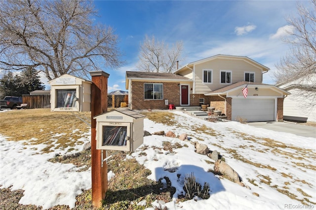 tri-level home featuring brick siding and fence