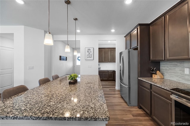 1168 Elbridge Dr, Elizabeth, CO 80107 - kitchen with stainless steel appliances, dark wood-type flooring, dark stone countertops, a center island, and dark brown cabinets