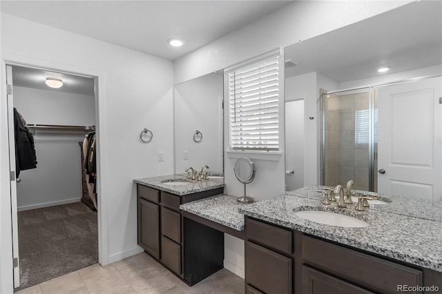 1168 Elbridge Dr, Elizabeth, CO 80107 - full bath with two vanities, a stall shower, a spacious closet, tile patterned floors, and baseboards