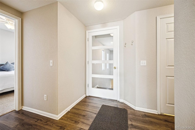 hall with dark wood-type flooring and baseboards