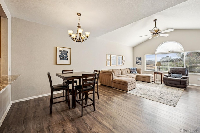 dining area featuring dark wood finished floors, lofted ceiling, ceiling fan with notable chandelier, and baseboards