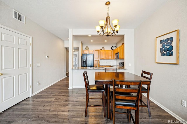 dining space with visible vents, baseboards, a chandelier, and dark wood-style flooring