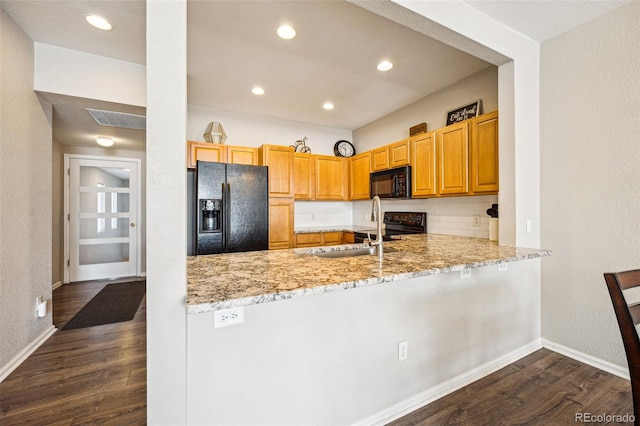 kitchen featuring dark wood finished floors, visible vents, black appliances, and a sink