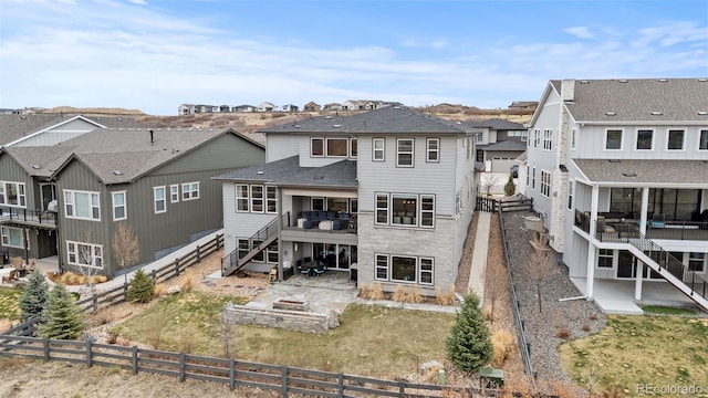 rear view of house with a fire pit, a residential view, a patio, stairway, and a fenced backyard