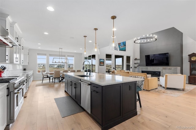 7077 Copper Sky Cir, Castle Pines, CO 80108 - kitchen featuring appliances with stainless steel finishes, a sink, light countertops, white cabinetry, and light wood finished floors