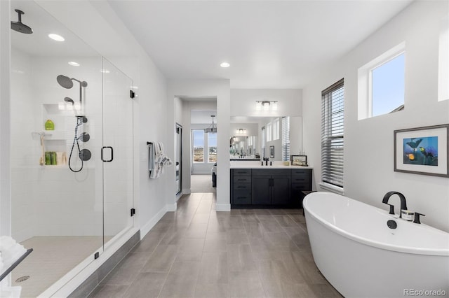 7077 Copper Sky Cir, Castle Pines, CO 80108 - bathroom featuring a stall shower, vanity, a soaking tub, and recessed lighting