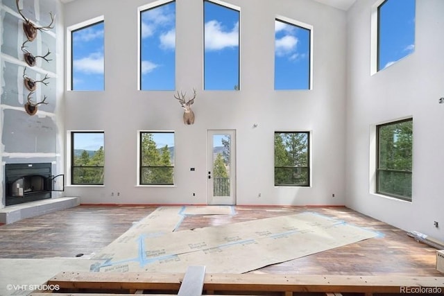 interior space featuring plenty of natural light, wood-type flooring, and a towering ceiling