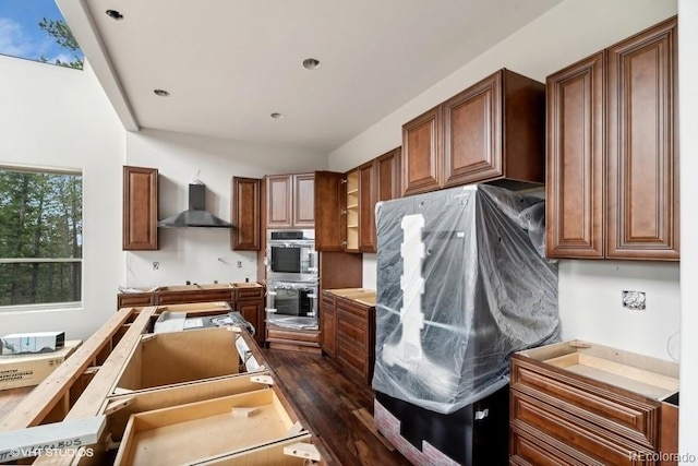 kitchen with refrigerator, double oven, and wall chimney exhaust hood