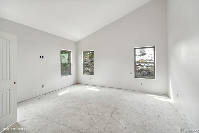 empty room featuring a healthy amount of sunlight and high vaulted ceiling