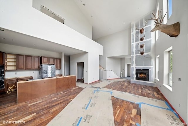 kitchen with appliances with stainless steel finishes, high vaulted ceiling, and hardwood / wood-style floors