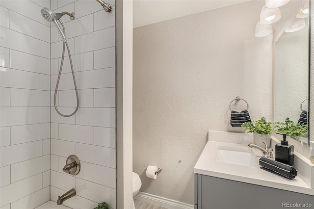 bathroom featuring shower / bath combination, vanity, toilet, and baseboards