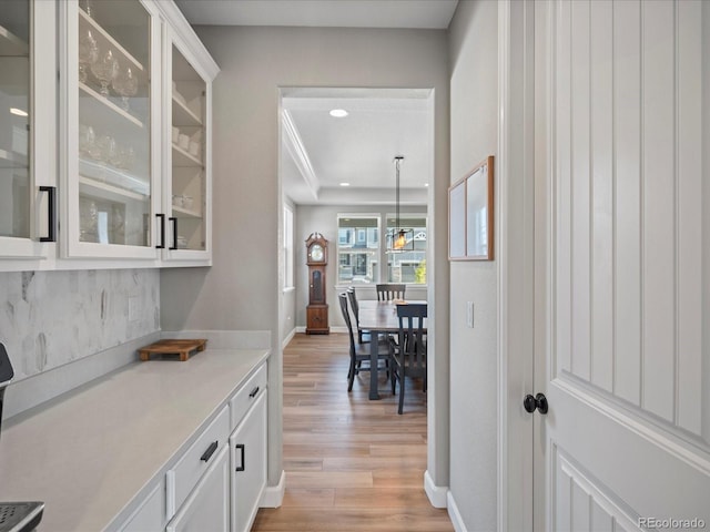 bar featuring white cabinets, pendant lighting, and light wood-type flooring