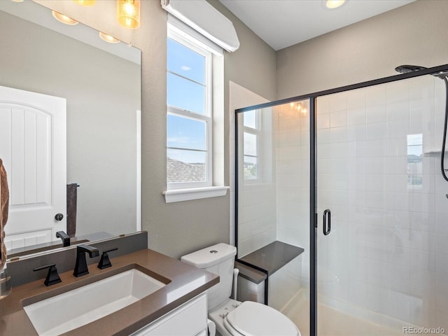 bathroom with toilet, vanity, and walk in shower