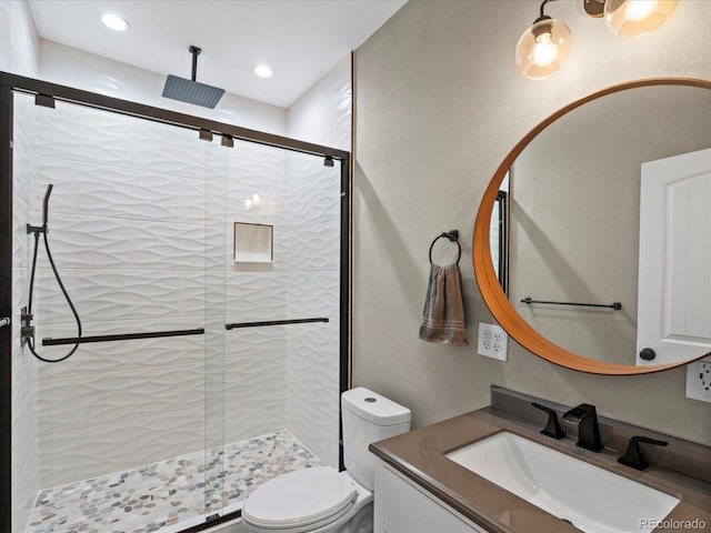 bathroom featuring vanity, an enclosed shower, and toilet