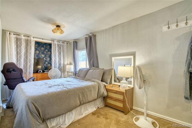 bedroom with light colored carpet, a textured wall, and baseboards