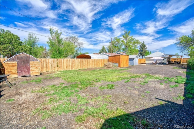 fenced backyard featuring a storage shed and an outdoor structure