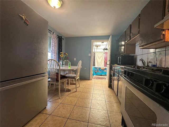 260 Sheridan Blvd, Denver, CO 80226 - kitchen featuring appliances with stainless steel finishes, tasteful backsplash, wall chimney exhaust hood, and light tile patterned floors