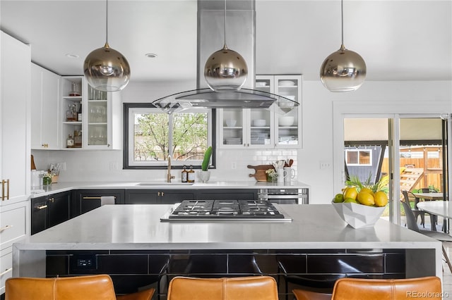 3103 W Bellewood Dr, Englewood, CO 80110 - kitchen featuring stainless steel appliances, island range hood, decorative backsplash, light countertops, and a sink