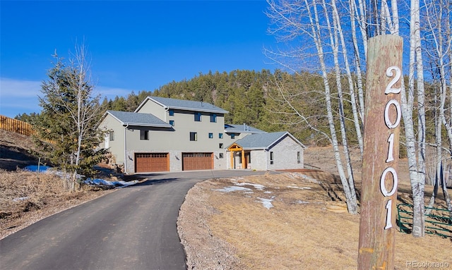 view of front of property featuring a garage, stucco siding, and aphalt driveway