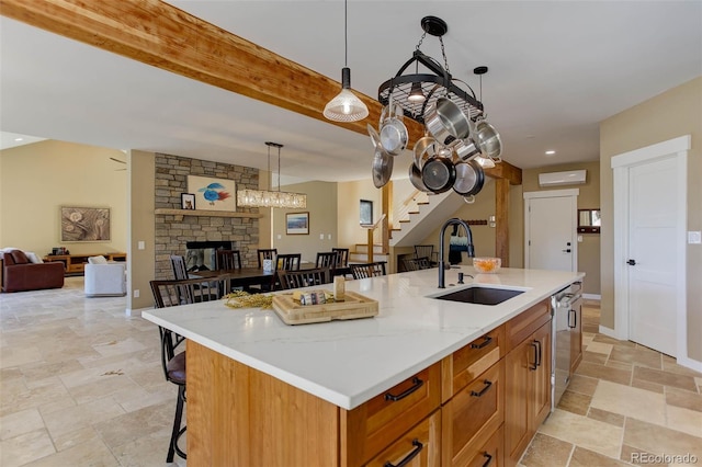 kitchen with a fireplace, a sink, open floor plan, dishwasher, and a wall mounted air conditioner