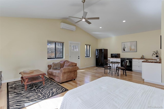 bedroom with baseboards, black fridge, light wood finished floors, and a wall mounted AC