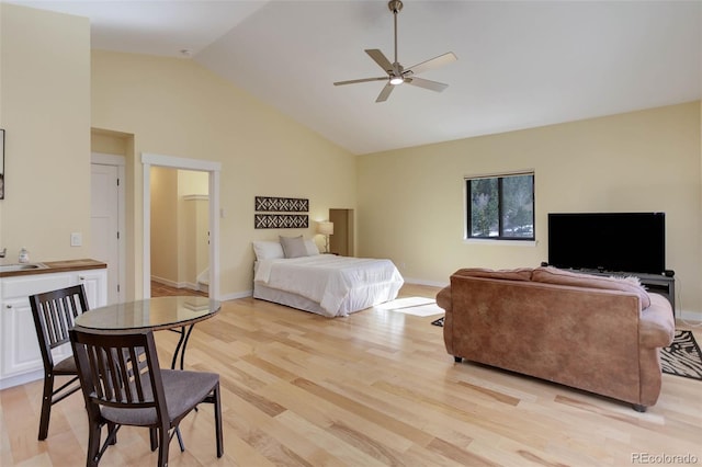 bedroom featuring light wood-style floors, a sink, high vaulted ceiling, and baseboards