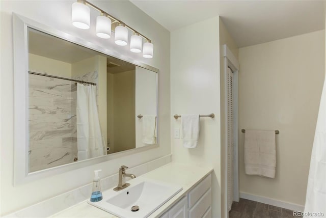 bathroom featuring a shower with curtain, baseboards, and vanity